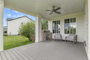 Wooden terrace with ceiling fan and a lawn