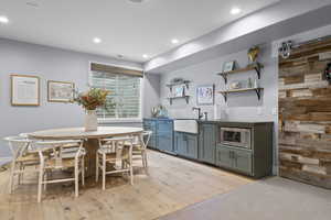 Dining space featuring bar with sink, recessed lighting, and light wood finished floors