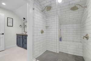 Bathroom with a shower stall, lofted ceiling, vanity, recessed lighting, and baseboards