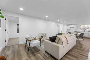 Living room with recessed lighting, wood finished floors, plenty of natural light, and baseboards