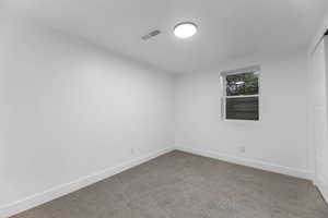 Spare room with carpet and baseboards