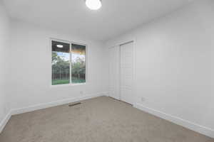 Unfurnished bedroom with baseboards, carpet floors, and a closet