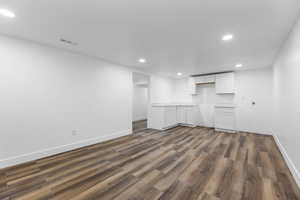 Finished basement with recessed lighting, dark wood-style flooring, and baseboards