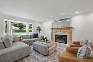 Living area with ornamental molding, a fireplace, recessed lighting, and a textured ceiling