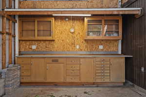 Kitchen featuring glass insert cabinets, unfinished concrete flooring, and light countertops
