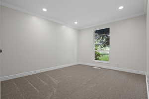 Carpeted empty room with recessed lighting, ornamental molding, and baseboards