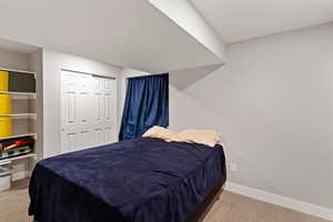 Bedroom with carpet floors, baseboards, and a closet