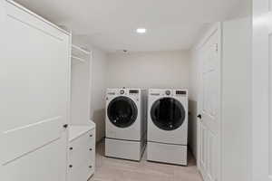 Laundry area featuring washing machine and dryer, light tile patterned flooring, and recessed lighting