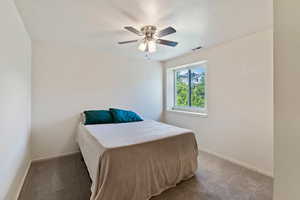 Bedroom with light carpet, baseboards, and a ceiling fan