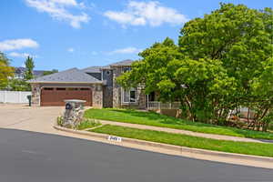 View of front of house featuring stone siding, a garage, and concrete driveway