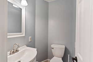 Half bathroom featuring a sink and toilet