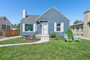 Bungalow featuring a chimney and a shingled roof