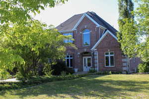 View of front of house featuring brick siding and a front lawn