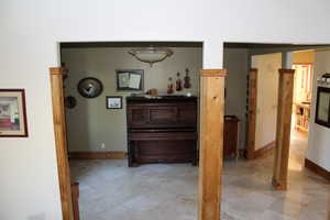 Corridor featuring baseboards and light tile patterned floors
