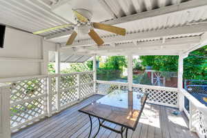 Wooden deck featuring a ceiling fan and outdoor dining area