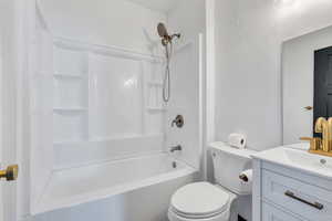 Full bath featuring toilet, vanity, and shower / washtub combination