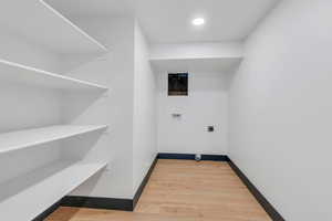 Laundry area featuring hookup for an electric dryer, washer hookup, wood finished floors, baseboards, and recessed lighting