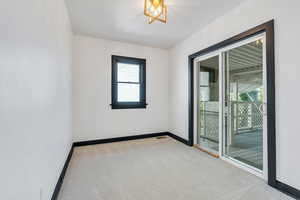 Unfurnished room featuring plenty of natural light, carpet flooring, and baseboards