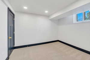 Carpeted spare room with recessed lighting and baseboards