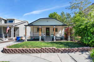 View of front of house with a porch, a front lawn, and brick siding