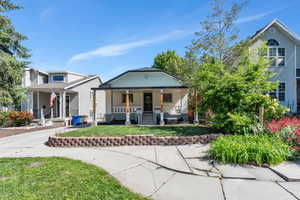 View of front facade featuring covered porch and a front lawn