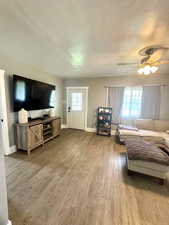 Living area with wood finished floors, baseboards, and a ceiling fan