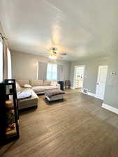 Living room with wood finished floors, baseboards, and ceiling fan