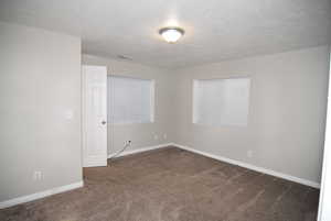 Bedroom #5 featuring carpet, a textured ceiling, and baseboards