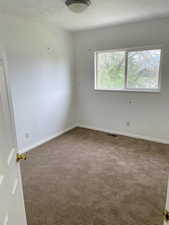 Empty room featuring carpet and baseboards
