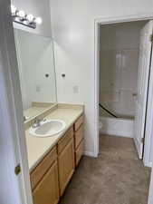 Full bath with vanity, toilet, bathing tub / shower combination, and baseboards
