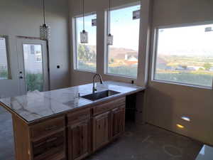 Kitchen with a sink, light countertops, and hanging light fixtures