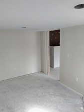 Unfurnished room with unfinished concrete flooring