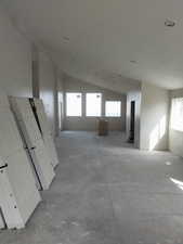 Unfurnished room featuring lofted ceiling