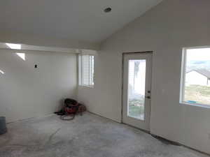Foyer featuring healthy amount of natural light, unfinished concrete floors, and lofted ceiling