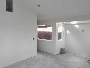 Unfurnished room featuring unfinished concrete flooring