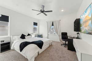 Bedroom featuring light carpet, an office area, ceiling fan, and recessed lighting