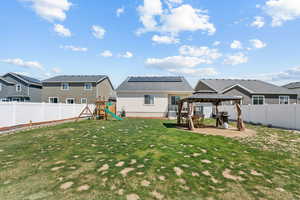Rear view of property with a gazebo, a playground, a residential view, stucco siding, and a patio area