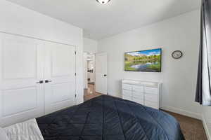 Bedroom featuring baseboards, a closet, and carpet