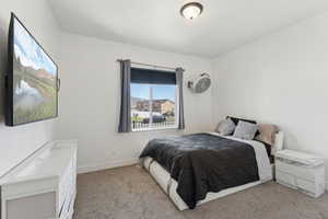 Bedroom with light colored carpet and baseboards