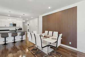 Dining area with dark wood-type flooring and recessed lighting