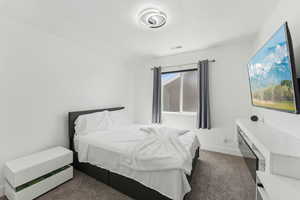 Carpeted bedroom featuring baseboards and a textured ceiling