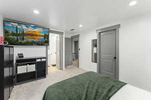 Bedroom featuring light colored carpet, recessed lighting, baseboards, and connected bathroom