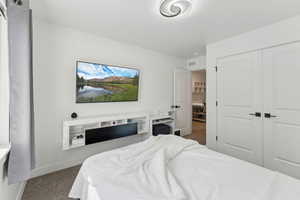 Carpeted bedroom featuring baseboards and a closet
