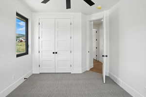 Unfurnished bedroom featuring carpet floors, a closet, and ceiling fan