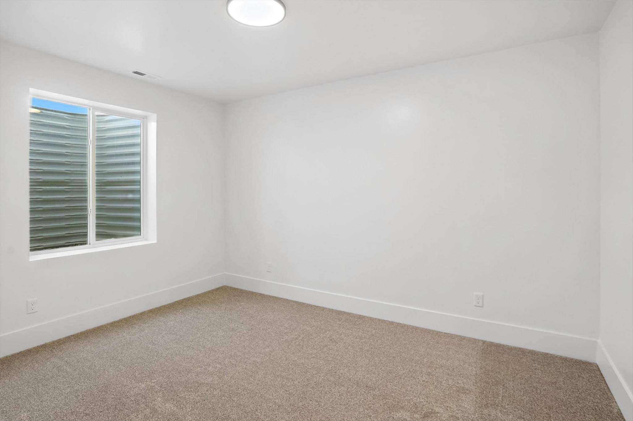 Empty room with light colored carpet