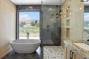 Full bathroom with tile walls, a soaking tub, a shower stall, vanity, and marble finish flooring