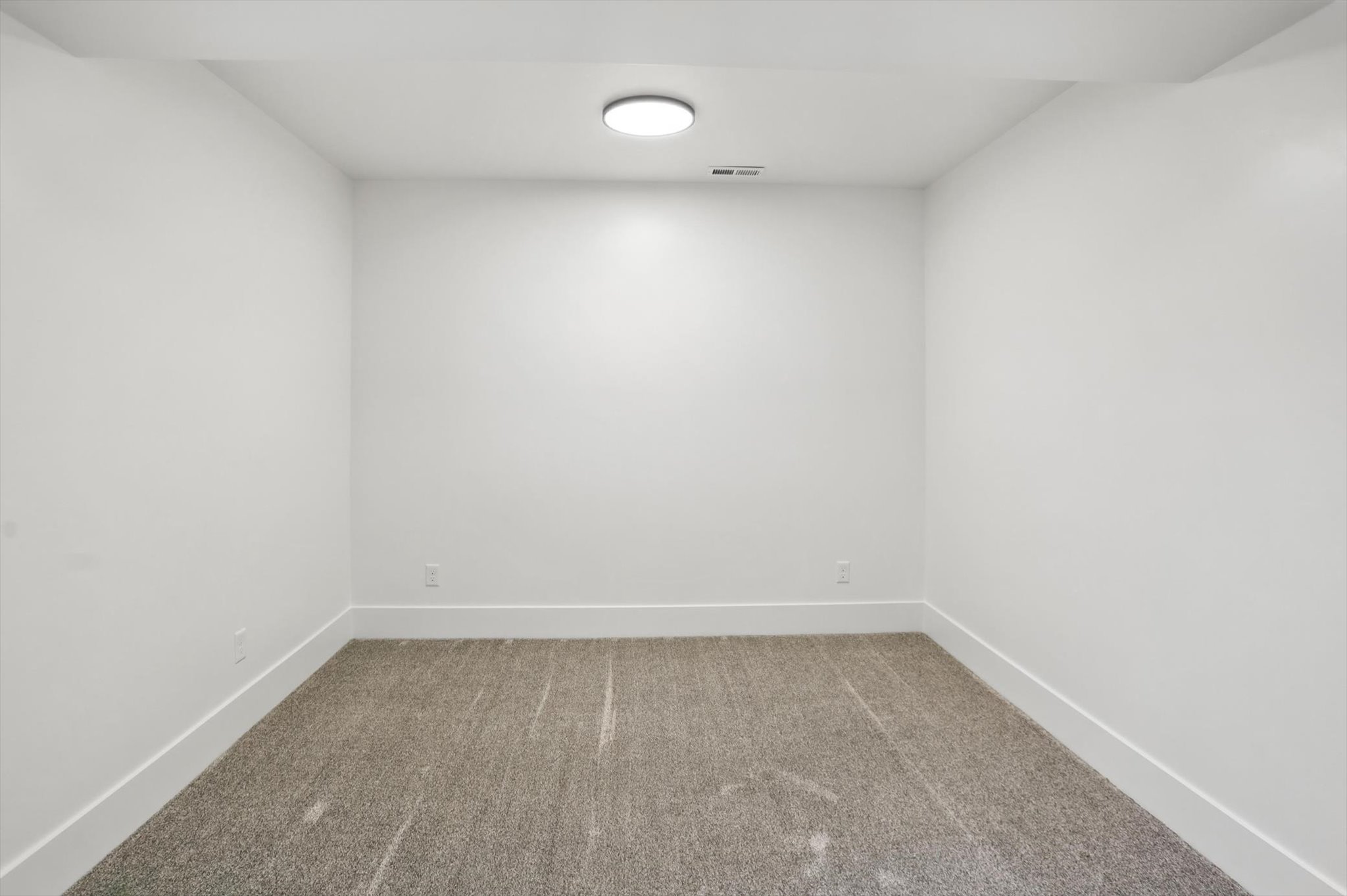 Carpeted spare room featuring baseboards