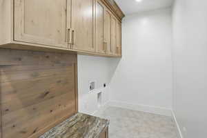 Laundry area featuring cabinet space, hookup for an electric dryer, washer hookup, and tile patterned flooring
