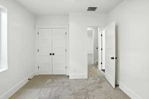 Unfurnished bedroom with carpet flooring and a closet