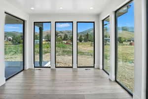 Unfurnished sunroom featuring a mountain view, wood-type flooring, and recessed lighting